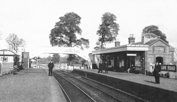 Photo of station with footbridge and level crossing